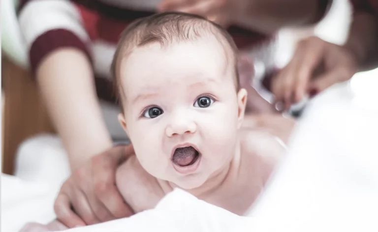 A baby being held by a female figure.